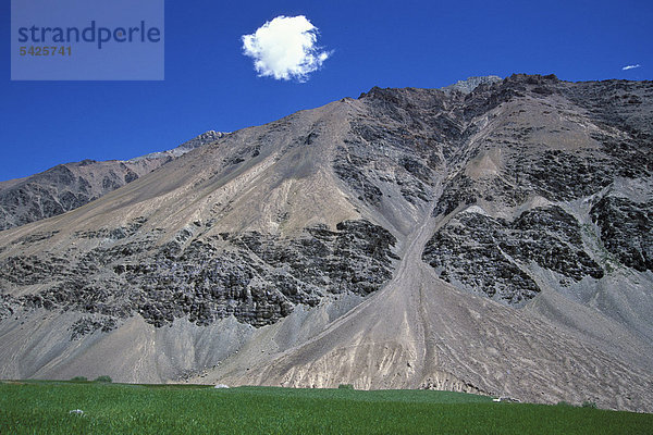 Wolke  schroffer Berghang und Felder  bei Tetha  Zanskar  Ladakh  Jammu und Kaschmir  Nordindien  Indien  Himalaya  Asien