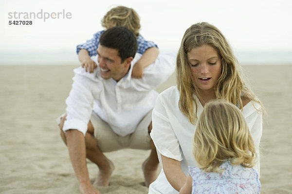 Familie spielt zusammen am Strand