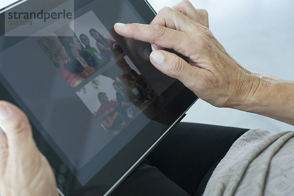 Frau beim Betrachten von Fotos auf digitalem Tablett  beschnitten