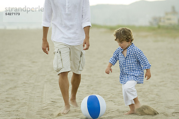Vater und Sohn beim Ballspielen am Strand