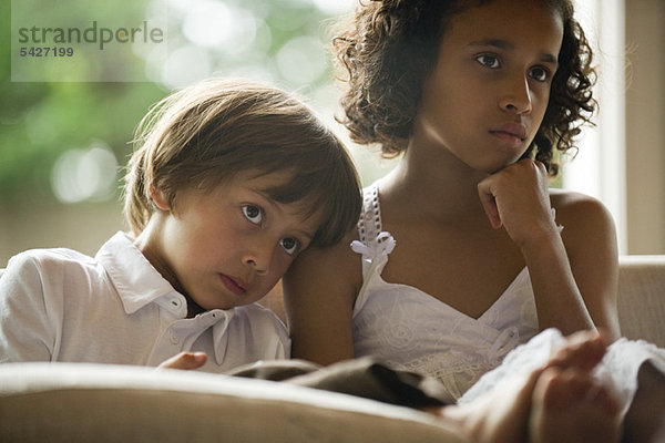 Kinder schauen zusammen fernsehen  Junge ruht Kopf auf Schwesternschulter