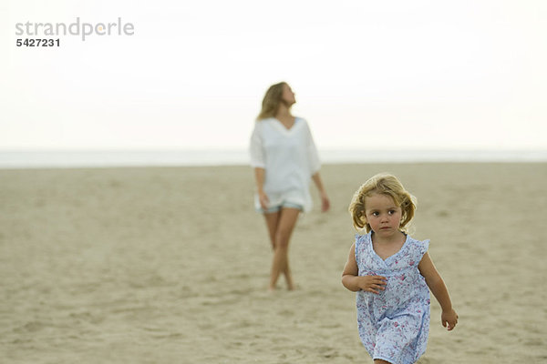 Kleines Mädchen  das am Strand spazieren geht
