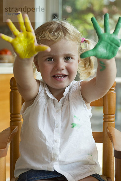 Kleines Mädchen mit Farbe an den Händen