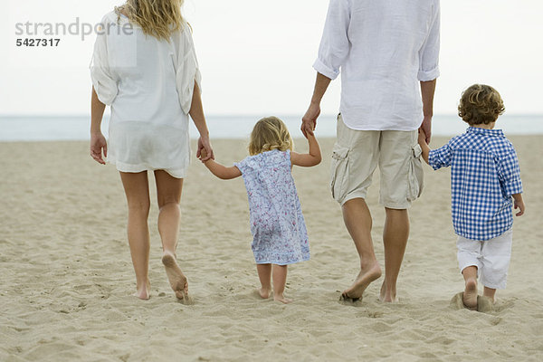 Familienspaziergang Hand in Hand am Strand