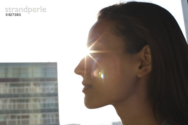 Silhouette des Frauengesichtes  die Sonne scheint im Hintergrund