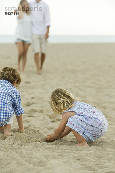 Kinder spielen im Sand am Strand