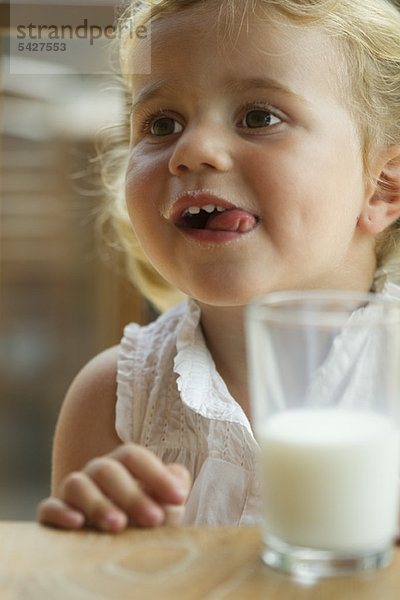 Kleines Mädchen genießt ein Glas Milch