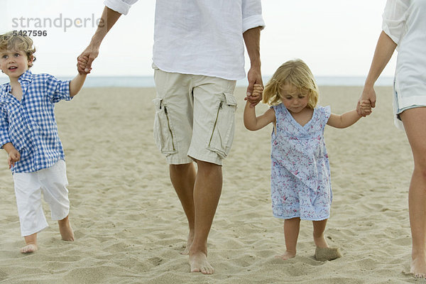 Familie geht Hand in Hand am Strand  abgeschnitten
