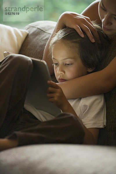 Junge und seine Mutter beim Betrachten des digitalen Tabletts