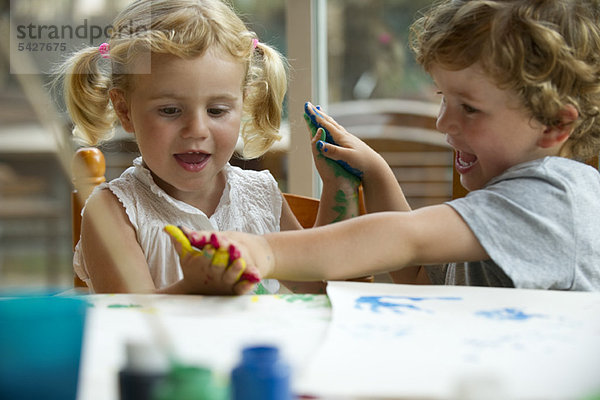 Kinder spielen gemeinsam mit Farbe