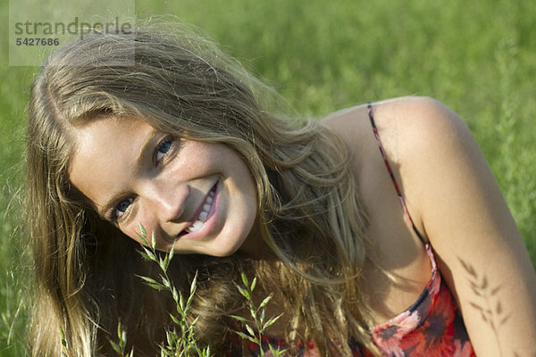 Junge Frau entspannt im hohen Gras  Portrait