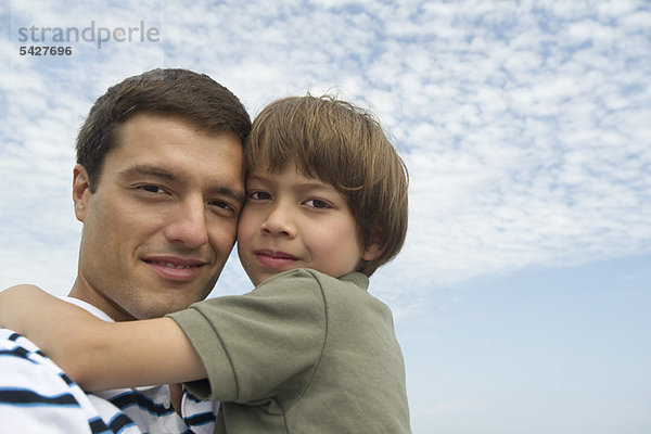 Vater und Sohn umarmen sich im Freien  Portrait