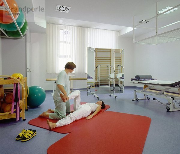 Eine Physiotherapeutin behandelt eine Patientin in der Physiotherapie.