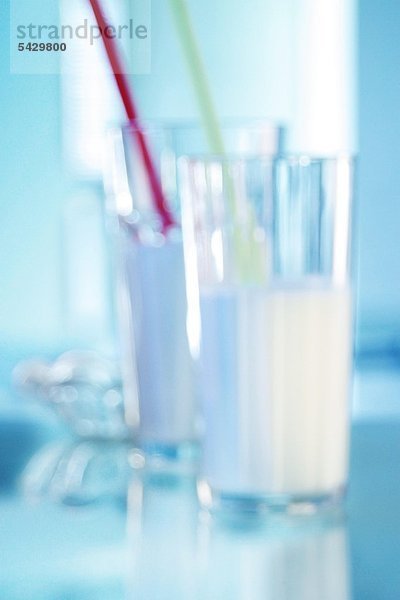 Zwei Milchgläser in der Unschärfe - Milch enthält Vitamin B1 B12 und Vitamin C sowie Kalzium Magnesium und Eiweiß - Sie dient dem Zahn- und Knochenaufbau