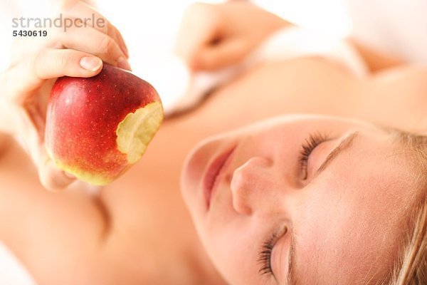 Frau isst Apfel nach Wellnessbehandlung . Gesunde Ernährung mund