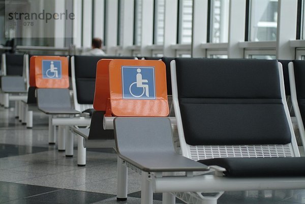 Sitzmöglichkeiten für Rollstuhlfahrer in einer Wartehalle auf dem Flughafen