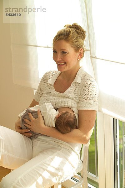 Eine Frau stillt ihr neugeborenes Kind
