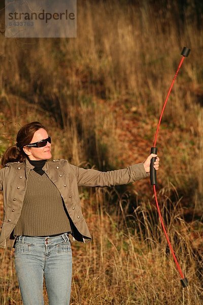 Frau mit Flexibar am Waldrand - Flexibar - Flexi-Bar - Der in Schwingung gebrachte Flexi-Bar bewirkt durch seine Vibration eine tiefgehende Reaktion des Körpers - reflektorische Anspannung des Rumpfes   effektiv gegen Rückenschmerzen - Zur Kräftigung der Tiefenmuskulatur   zur Kraftausdauer   zur Straffung des Bindegewebes   zur Verbesserung der Körperhaltung - Bodystyling