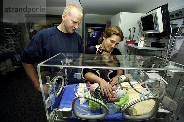 Säuglingstation eines Krankenhauses   Eltern am Brutkasten ihres zu früh geborenen Säuglings -