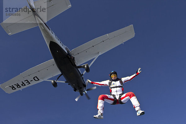 Fallschirmspringerin springt aus dem Flugzeug