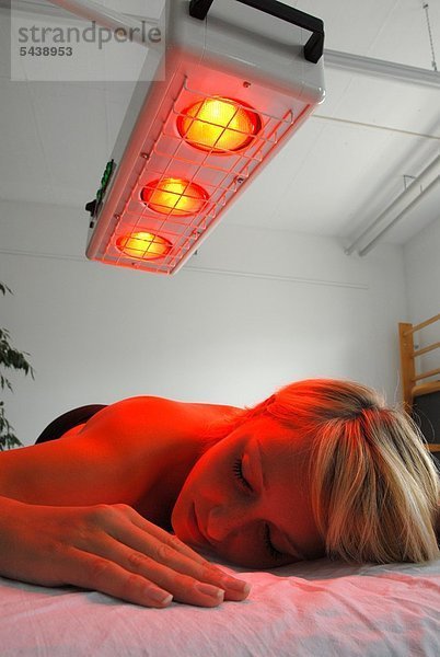Nackte junge Frau unter Rotlicht / Heissluft   Massage