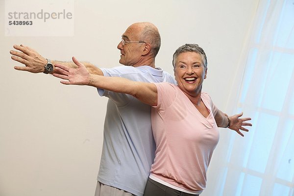 ältere Frau und älterer Mann machen zusammen Gymnastik - Senioren