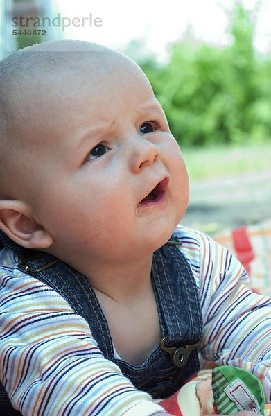 Baby 6 Monate liegt auf einer Decke im Garten