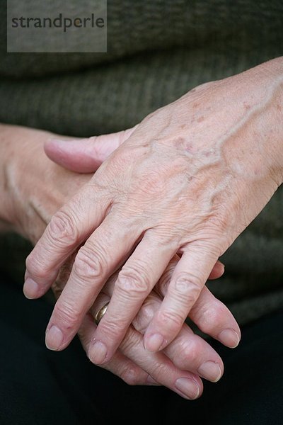 zwei Hände einer älteren Frau mit Gicht und Altersflecken - Altersfleck