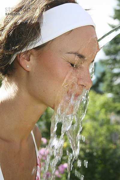 Kalter Gesichtsguss nach Kneipp - Bei einer jungen Frau wird das Gesicht mit kaltem Wasser abgegossen