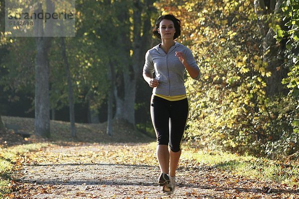 Junge Frau beim Jogging an einen sonnigen Herbsttag