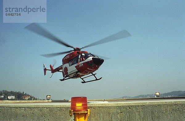 Helikopter der Rettungsflugwacht beim Landeanflug auf Krankenhausdach