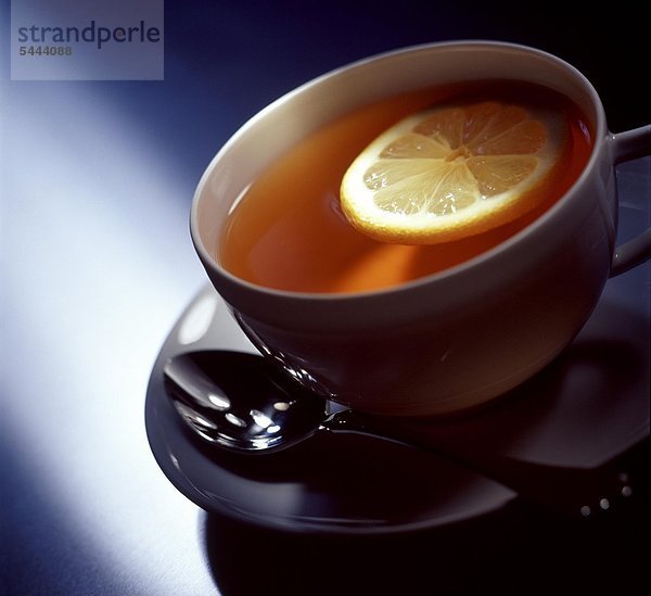 Eine Tasse gefüllt mit Tee und einer Scheibe Zitrone