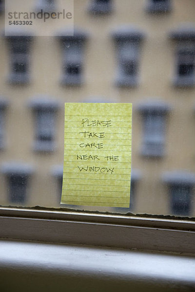 Handgeschriebene Haftnotiz zur Erinnerung an Please Take Care Near The Window