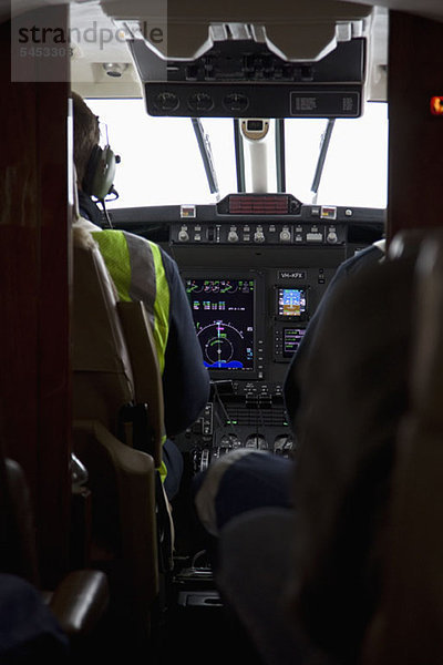 Pilot und Co-Pilot im Cockpit eines Flugzeugs  Rückansicht