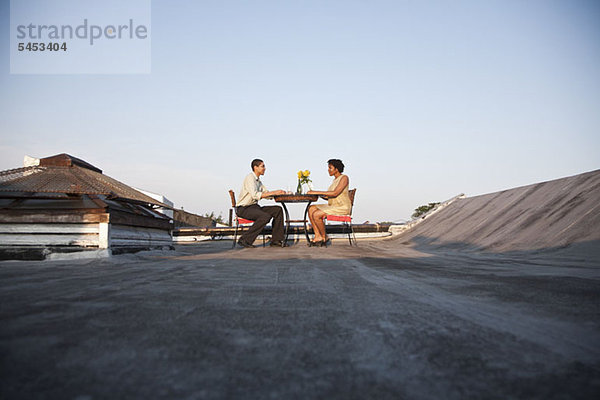 Ein Paar beim Essen auf der Dachterrasse