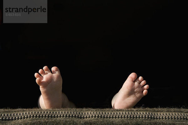 Die Fußsohlen eines Babys liegen auf einem Kissen.