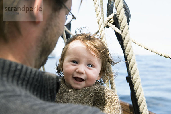 Ein aufgeregtes Baby mit ihrem Vater auf einem Boot