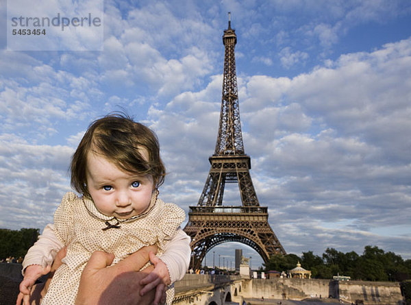 Ein Baby wird vor dem Eiffelturm gehalten  Paris  Frankreich