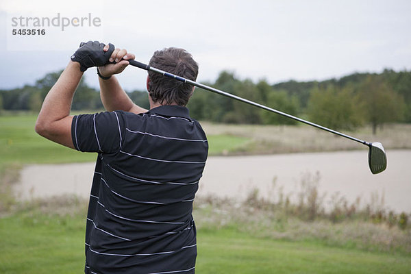 Ein Golfer beim Abschlag  Rückansicht  Taille oben