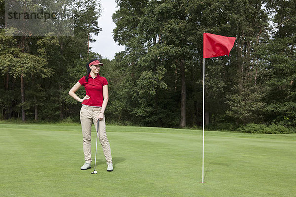 Eine Golferin steht auf einem Putting Green