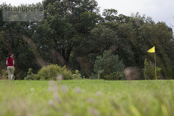 Eine Golferin auf einem Putting Green  Rückansicht