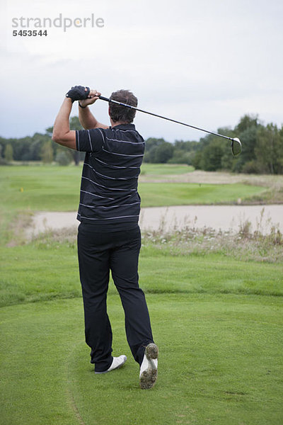 Ein Golfspieler beim Abschlag  Rückansicht