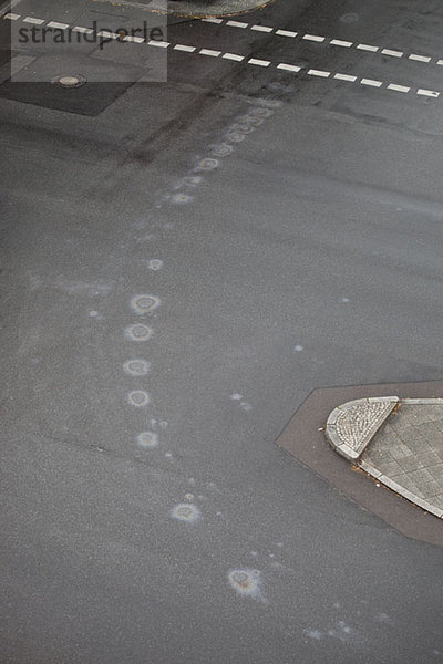 Kreisförmige Ölflecken auf einer Straße  Hochwinkelansicht