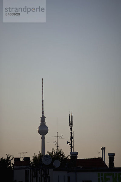Der Fernsehturm am Alexanderplatz hinter einem Dach mit Antennen