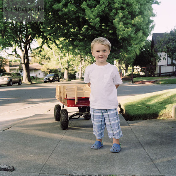 Ein Junge mit einem Spielzeugwagen  Portrait