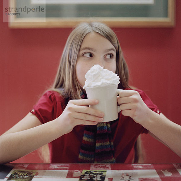 Ein Teenager-Mädchen mit einer Tasse heißer Schokolade.