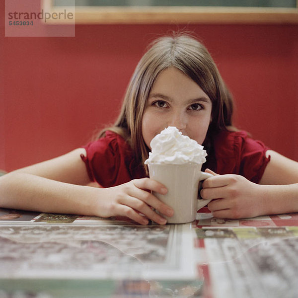 Ein Teenagermädchen mit einer Tasse heißer Schokolade.