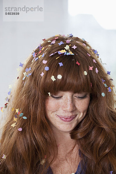 Eine junge Frau mit Konfetti im Haar.