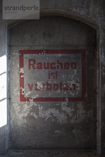 Schild'Rauchen ist verboten' auf der verlassenen Betonwand