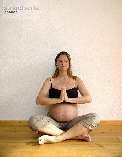 Schwangere Frau macht eine Yogaübung
